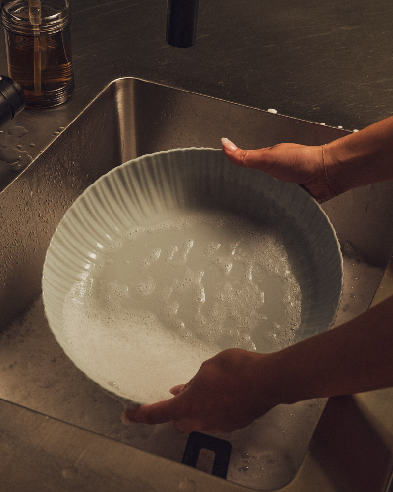 Light Blue Grey Banksia Bowl being washed in a sink. Photograph by Sarah Forgie