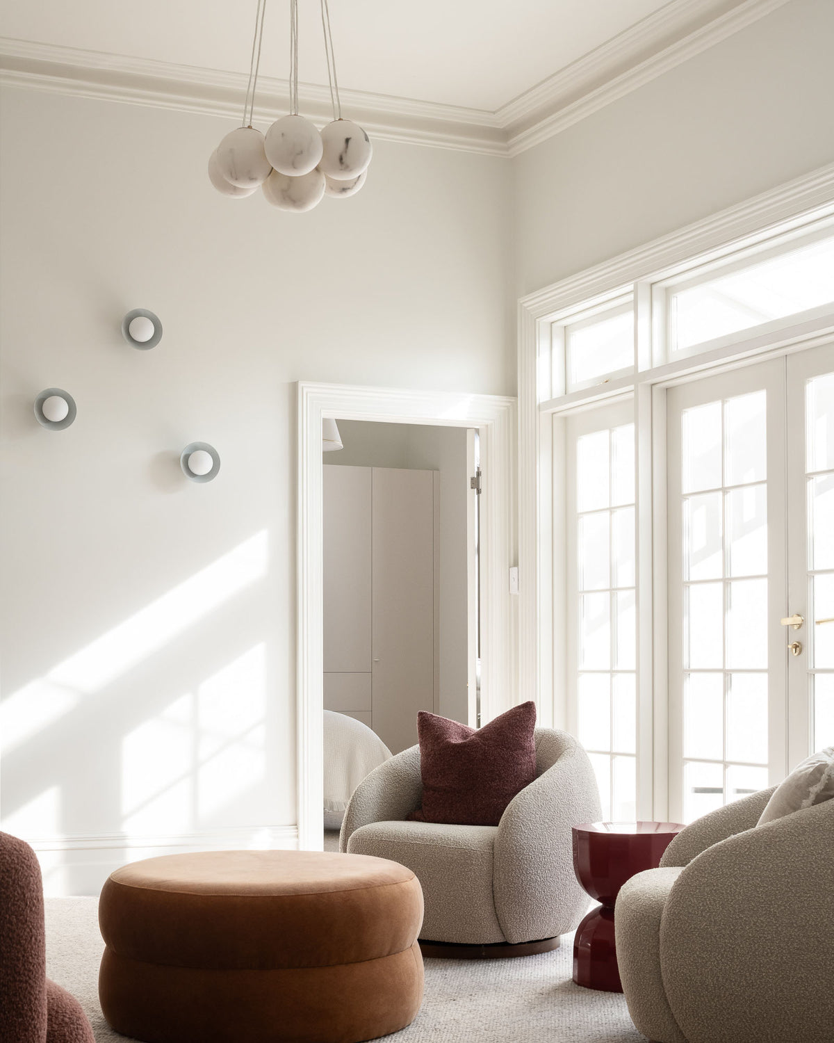 Three Pixie Wall Sconces floating across a living room wall. Project by Grant Compton Interior Design, architecture by 6ty, built by 3D Construction and Developments. Photograph by Anjie Blair