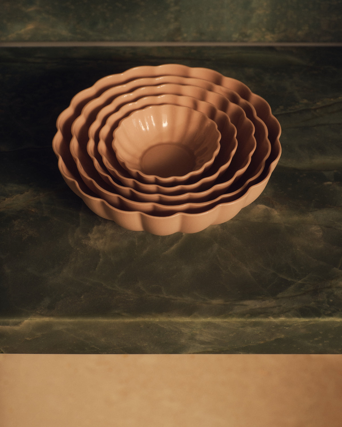 Fern Nesting Bowls in Whispery Pink, nested on green marble. Photograph by Sarah Forgie