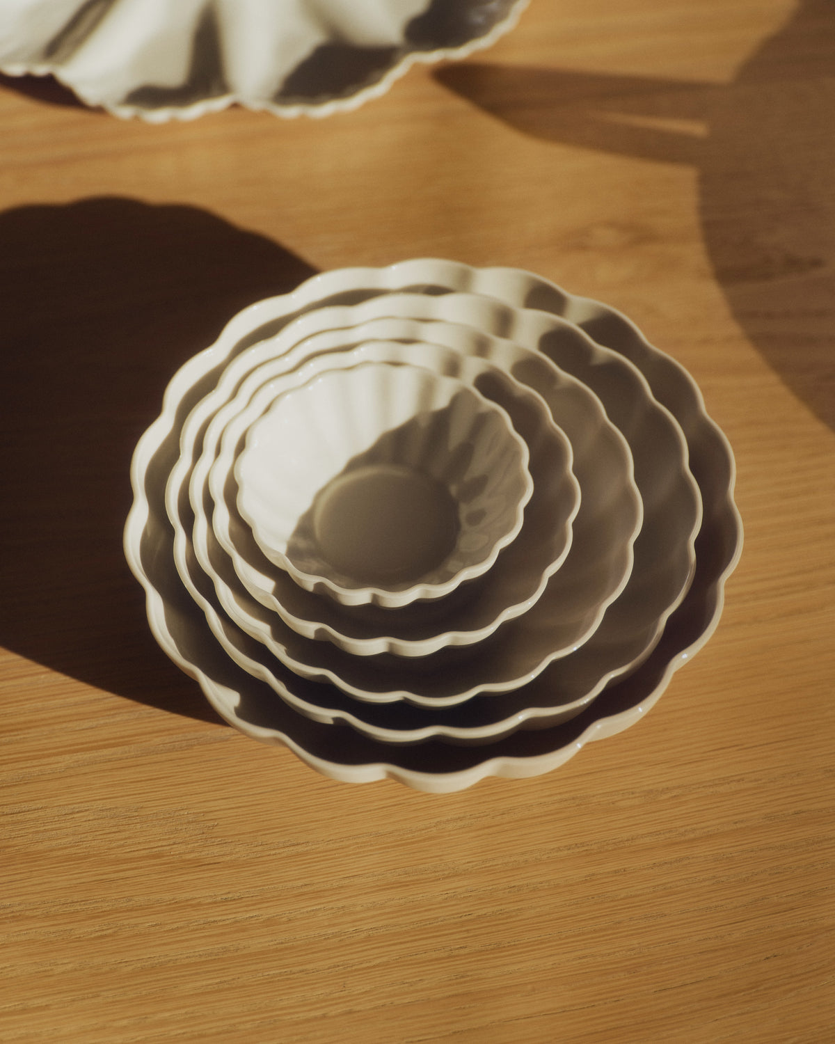 Fern Nesting Bowls, Complete Set of 5 in Natural White, nested on a timber table. Photograph by Sarah Forgie